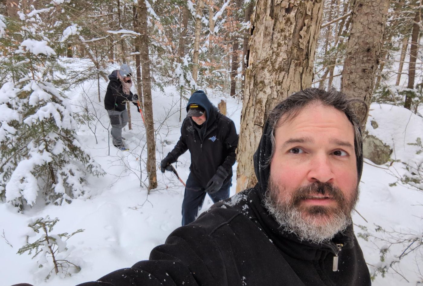 campers snowshoeing through the snowy winter woods at Bartertowne, Canaan New Hampshire