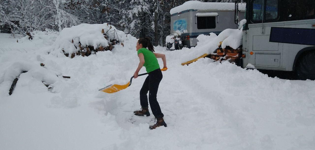 shoveling snow by the bus camp at Bartertowne, Canaan New Hampshire
